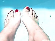 My feet in red polish in a pool