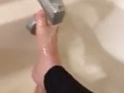 Alexis Black rubs her feet in the bath with leggings