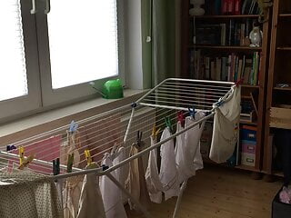 Cd crossdresser hanging up laundry in...