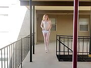Trans goddess struts in platforms on balcony 