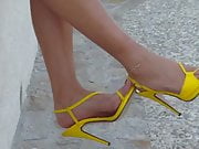 3 Walking around in yellow strappy high heel sandals.